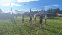 Pfadfinder stehen auf einer Wiese und Spielen Volleyball.